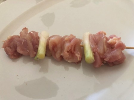 putting chicken pieces anf onions on skewer