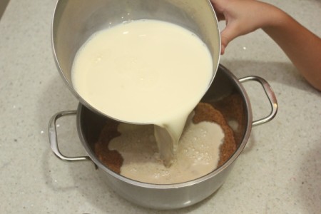 Wet ingredients being added to the dry ingredients for butterscotch pudding.