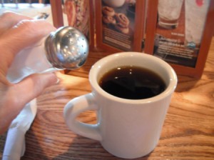 Adding salt to a cup of strong coffee.