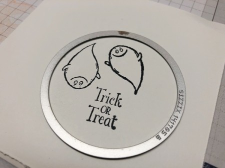 A circular metal pattern to cut out the decal for the front of the card.