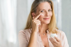 Woman applying moisturizer.