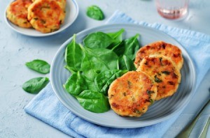 Salmon patties on a plate with spinach.