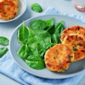 Salmon patties on a plate with spinach.