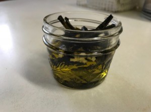 Placing peppers in a jar with oil.