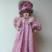 Identifying a Porcelain Doll - doll wearing deep pink long dress and fancy hat