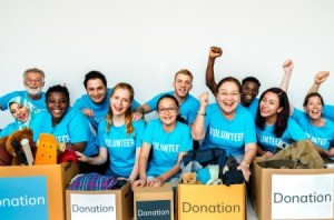 Group of volunteers in blue shirts with boxes of donations.