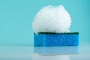 Blue sponge with soap foam on top.
