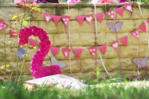 Number 2 party decoration covered in pink flowers.