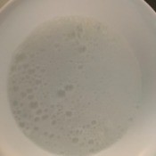 A bowl of baking powder that is bubbling slightly.