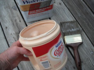 An easy to hold Coffee-mate plastic container with paint inside.