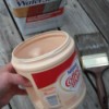 An easy to hold Coffee-mate plastic container with paint inside.