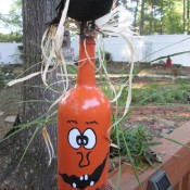 Jack-'o-Lantern Painted Wine Bottles - bottle painted, with raffia around the neck, hair and a bow tie