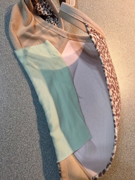 A patch sewed to the bottom of a bra's cup.