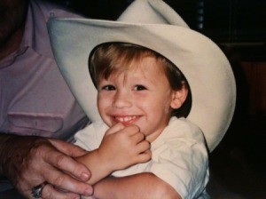 A small boy in a large white cowboy hat.