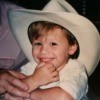 A small boy in a large white cowboy hat.