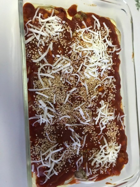 Eggplant covered with sauce, sesame seeds and cheese