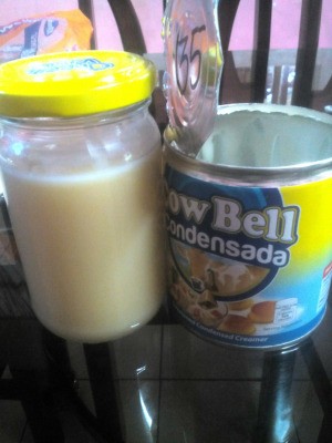 A can stored next to a jar fill of condensed milk.