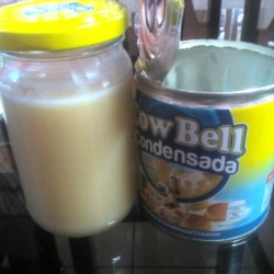 A can stored next to a jar fill of condensed milk.
