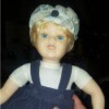 Value of a Porcelain Doll - doll wearing a blue jumper and plaid hat