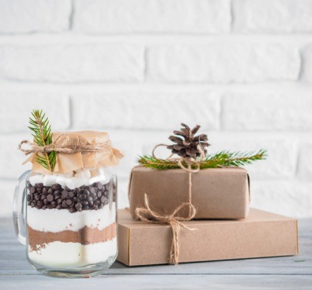 Gift mix in a jar next to boxed gifts.