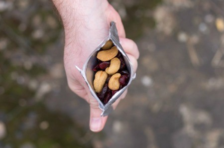 Hand holding a bag of trail mix.