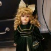 Value of a Collector's Choice Doll by Dandee - doll with gold ringlets, a large hair bow and a long dark coat