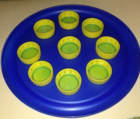 Repurpose Old Food and Storage Lids for Paint Palettes - small bottle caps arranged on larger lid