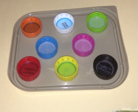 Repurpose Old Food and Storage Lids for Paint Palettes  - colored soda and water bottle caps on a squarish container lid as another option