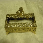 A vintage gold trinket on a white background.