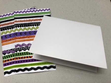 A step in making a Halloween card with a decorative pumpkin silhouette.