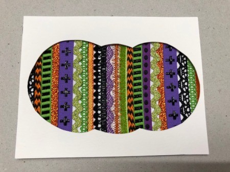 A step in making a Halloween card with a decorative pumpkin silhouette.