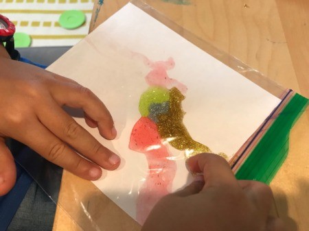 Glitter Art in a Ziploc Bag - child pressing and smearing the glitter glue