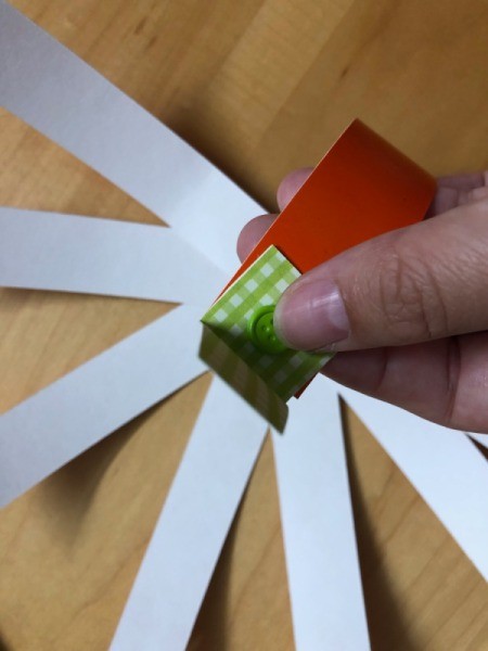 Pumpkin Garland - start folding up the pumpkin strips and inserting the end on the brad