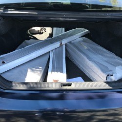 Shelving pieces removed from packaging and placed in a car's trunk.