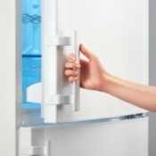 Hand opening a freezer door.