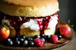 Naked berry cake surrounded by berries.