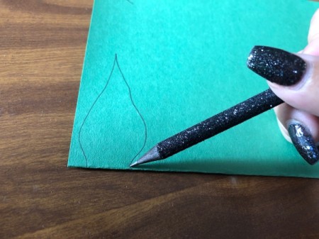 Hanging Paper Pumpkins - fold green paper in half and sketch a leaf pattern at the fold