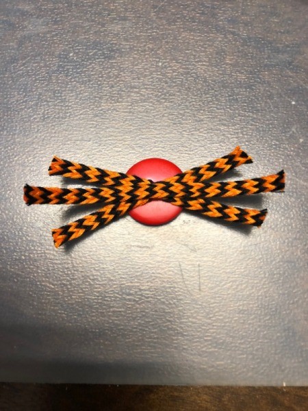 Spiderweb Display Sign - six legged spider as seen from back of the button