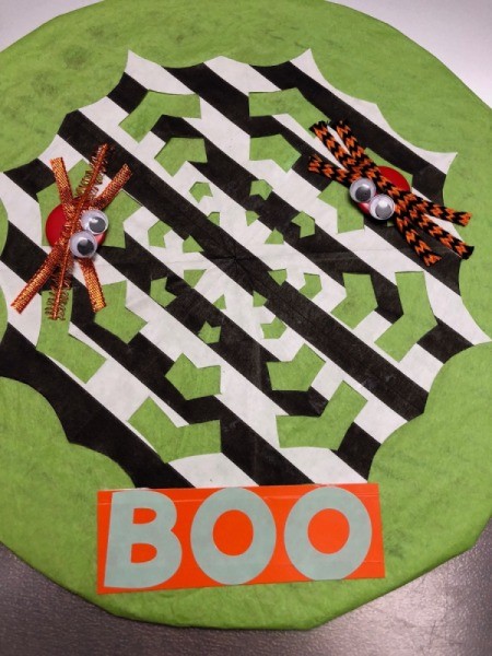 Spiderweb Display Sign - BOO spelled out in stickers on orange paper and stuck to bottom center of green circle