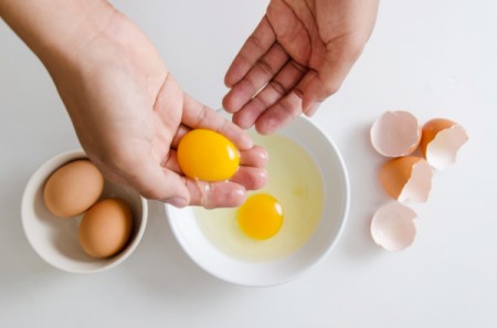 Separating egg yolks from the whites with your hands.