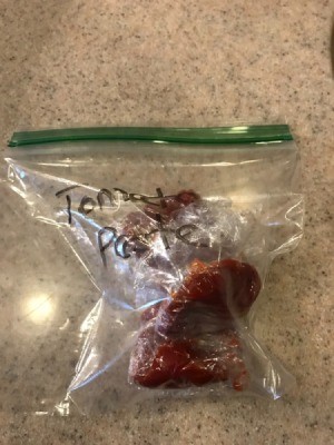 A tablespoon of tomato paste in a plastic bag.