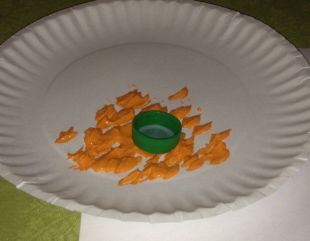 Bottle Cap Pumpkin Stamping - dip soda bottle cap into orange paint on a paper plate