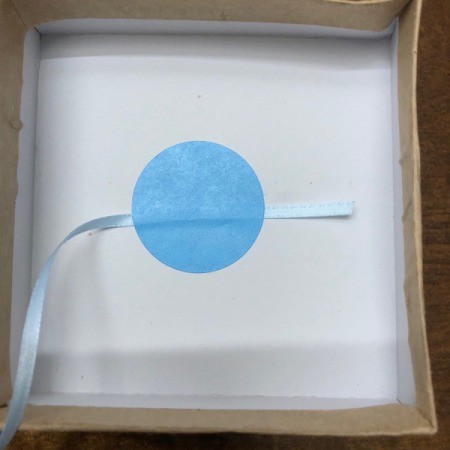 Gender Reveal Surprise in a Box - attach one end of the ribbon to the inside bottom of the box with a sticker and recover with the foam insert