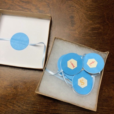 Gender Reveal Surprise in a Box - stickers on ribbon wound up in the box with other end attached to the inside of the lid