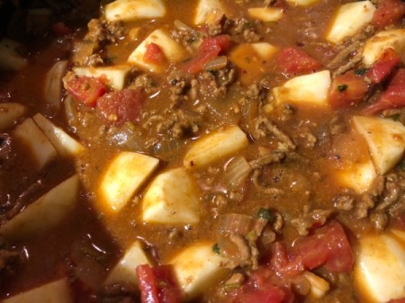 adding tomatoes to stew