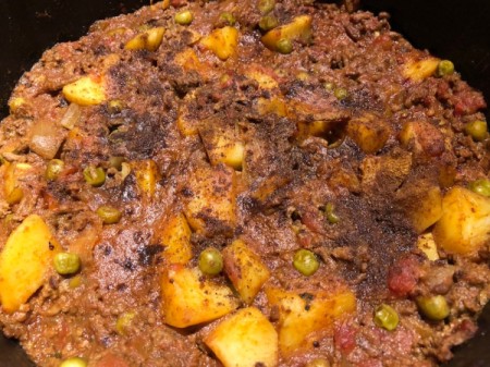 sprinkling garam masala on top of stew