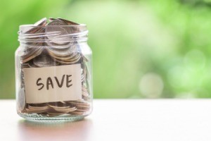 Jar full of coins with the word "save" on the outside.