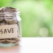 Jar full of coins with the word "save" on the outside.