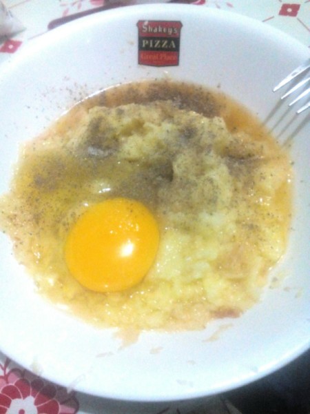 adding egg to grated potatoes and garlic