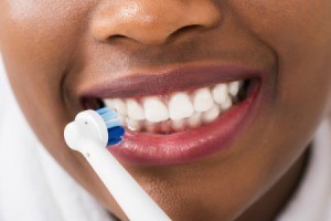 Woman brushing her white teeth.